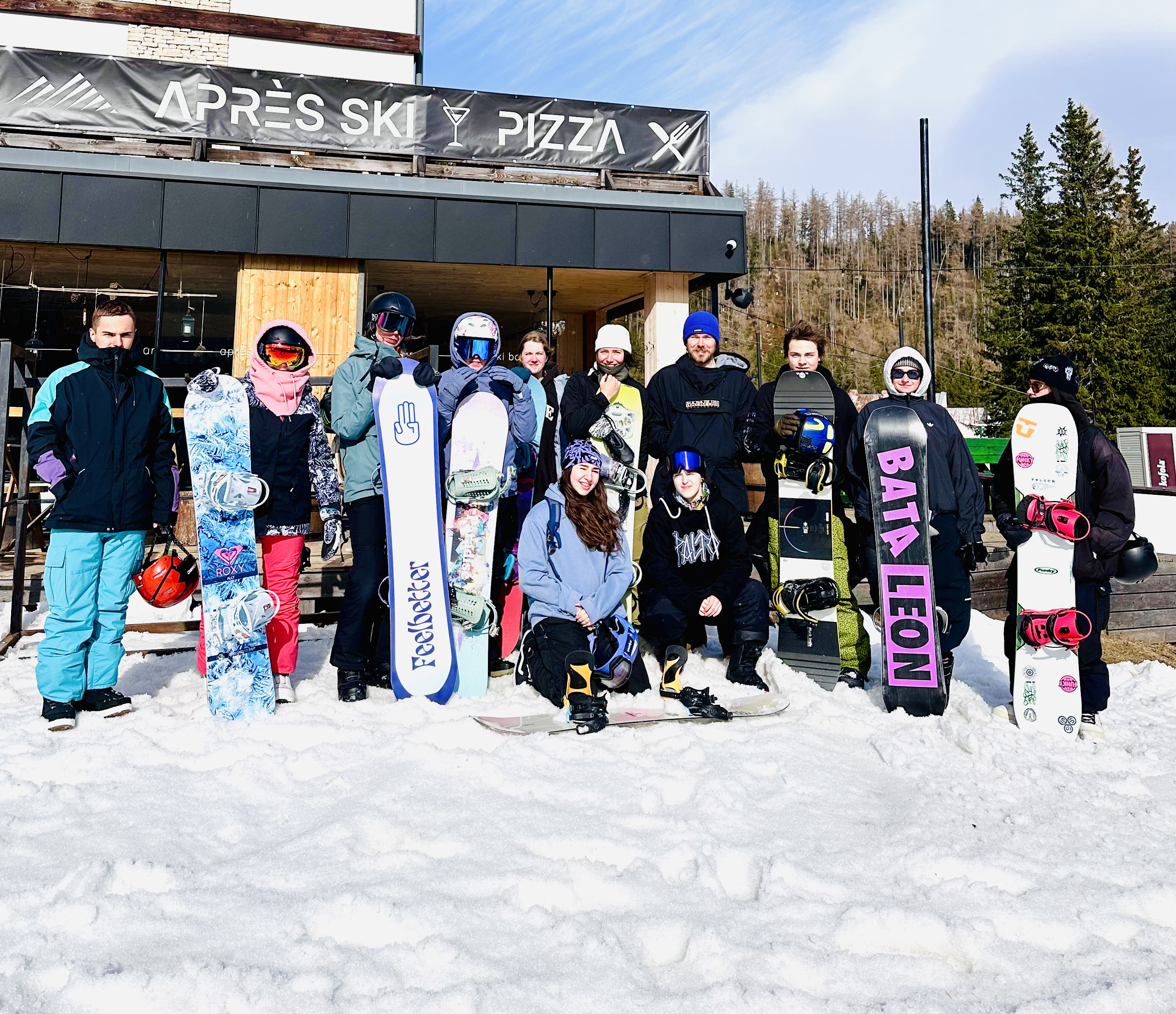 zdjęcie grupowe z flagą szkółki podczas szkolenia na stoku narciarskim